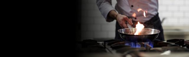a chef cooks a meal over a gas stove