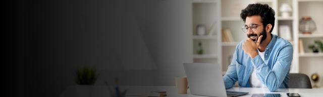 man considering utility costs at a computer in his home