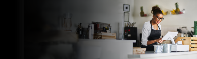 Female cafe worker looking at cash register