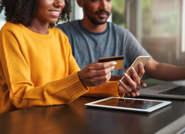 a couple using a credit card to shop online