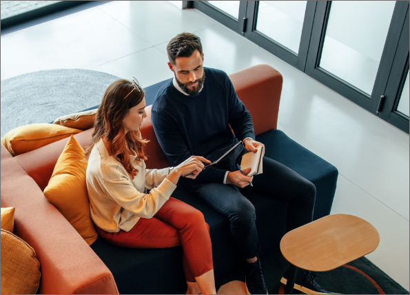 two business people sitting on a couch discussing utility data