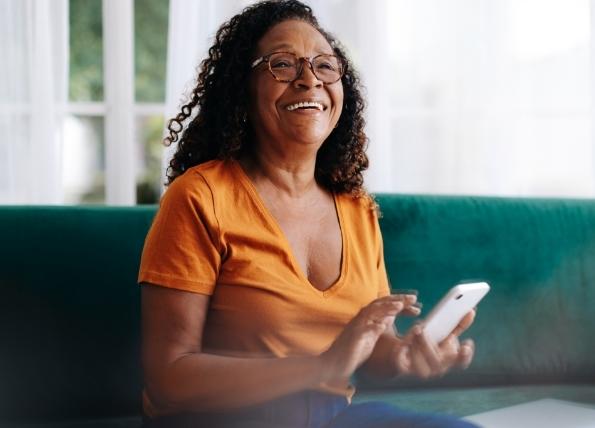 woman smiling as she looks over utility information on her mobile phone