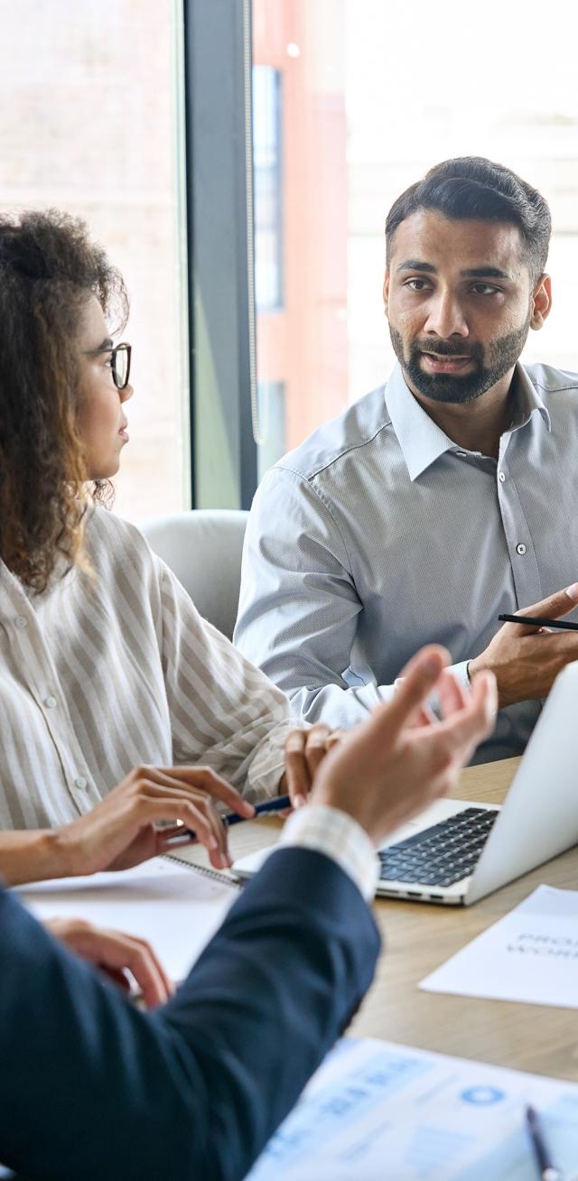 A businessman discusses financial services benchmarking with his team