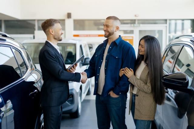 A sales person meeting two customers who used J.D. Power auto retailing tools