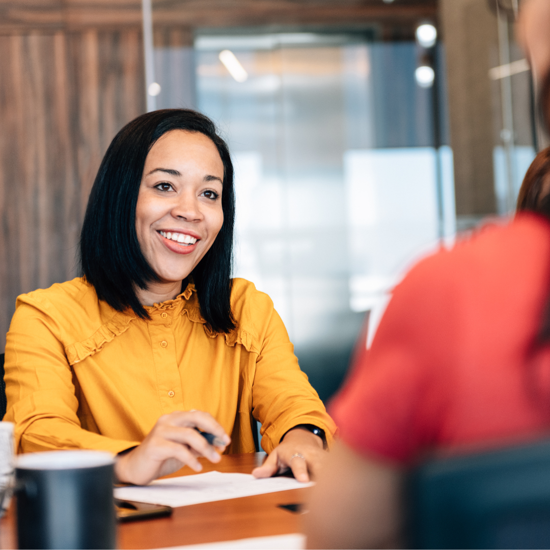A friendly bank advisor speaking with a customer across a desk