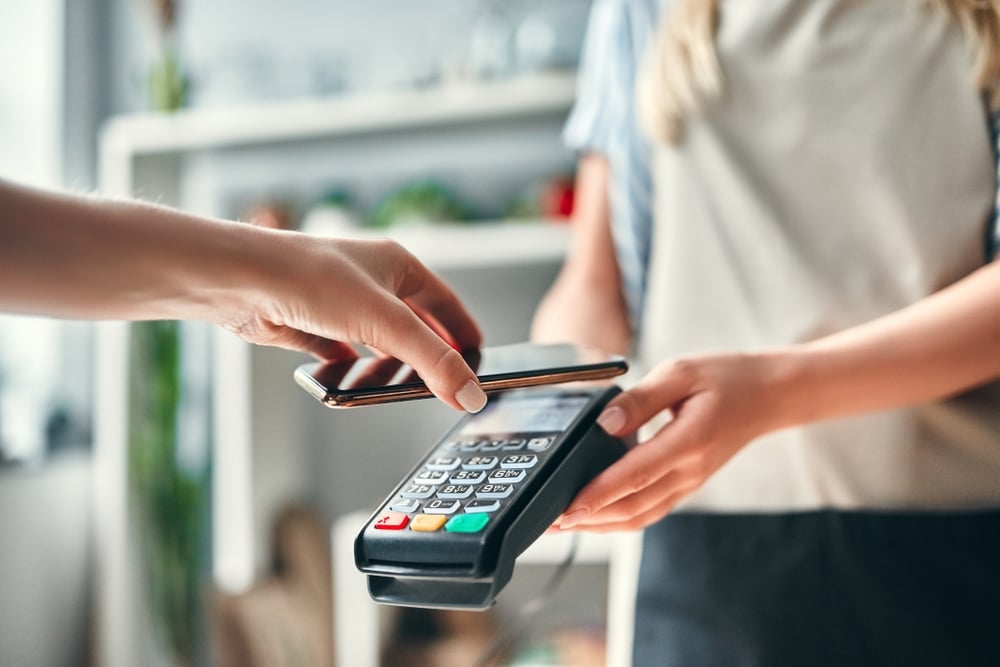 woman using apple pay later to purchase goods in a flower shop