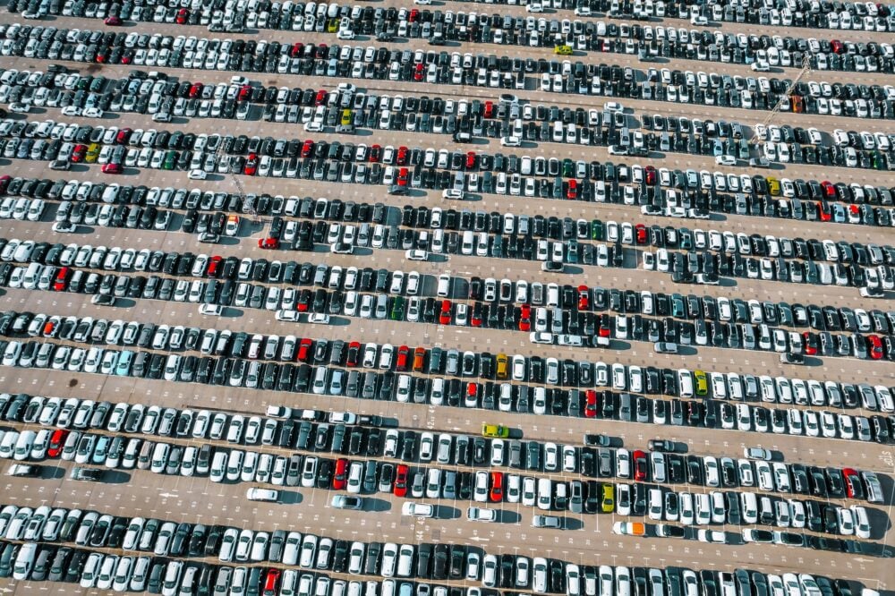 Aerial view of the stock of a large number of cars parked with order outside of an automobile company.|
