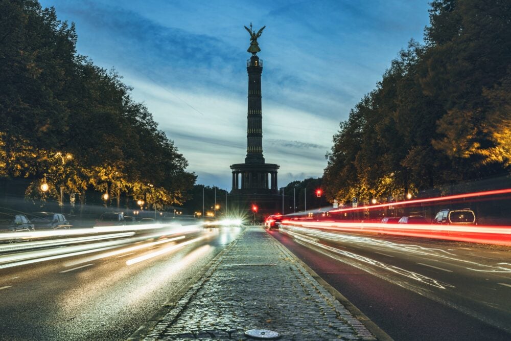 long exposure of rush hour traffic in front of Berlin victory column at sunset in autumn|
