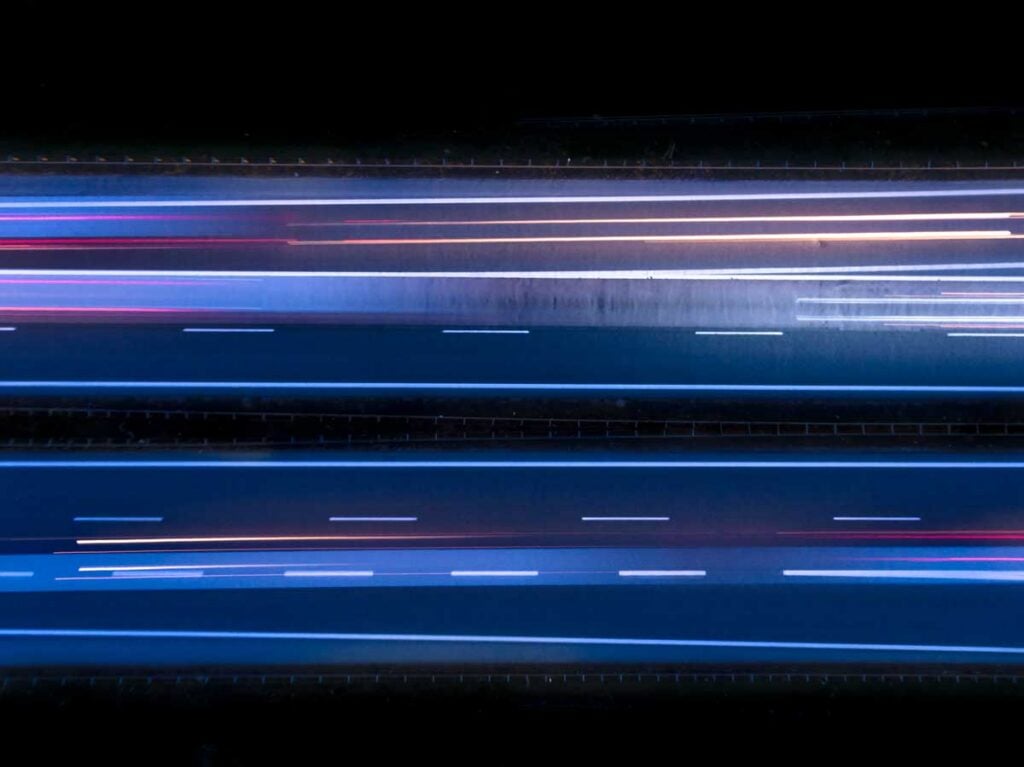 Aerial view, view from above, drone view, or birds eye view of a highway at night.