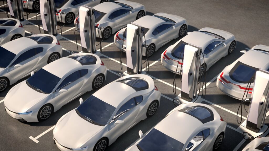 Aerial of a fleet of white EVs parked at charging stations