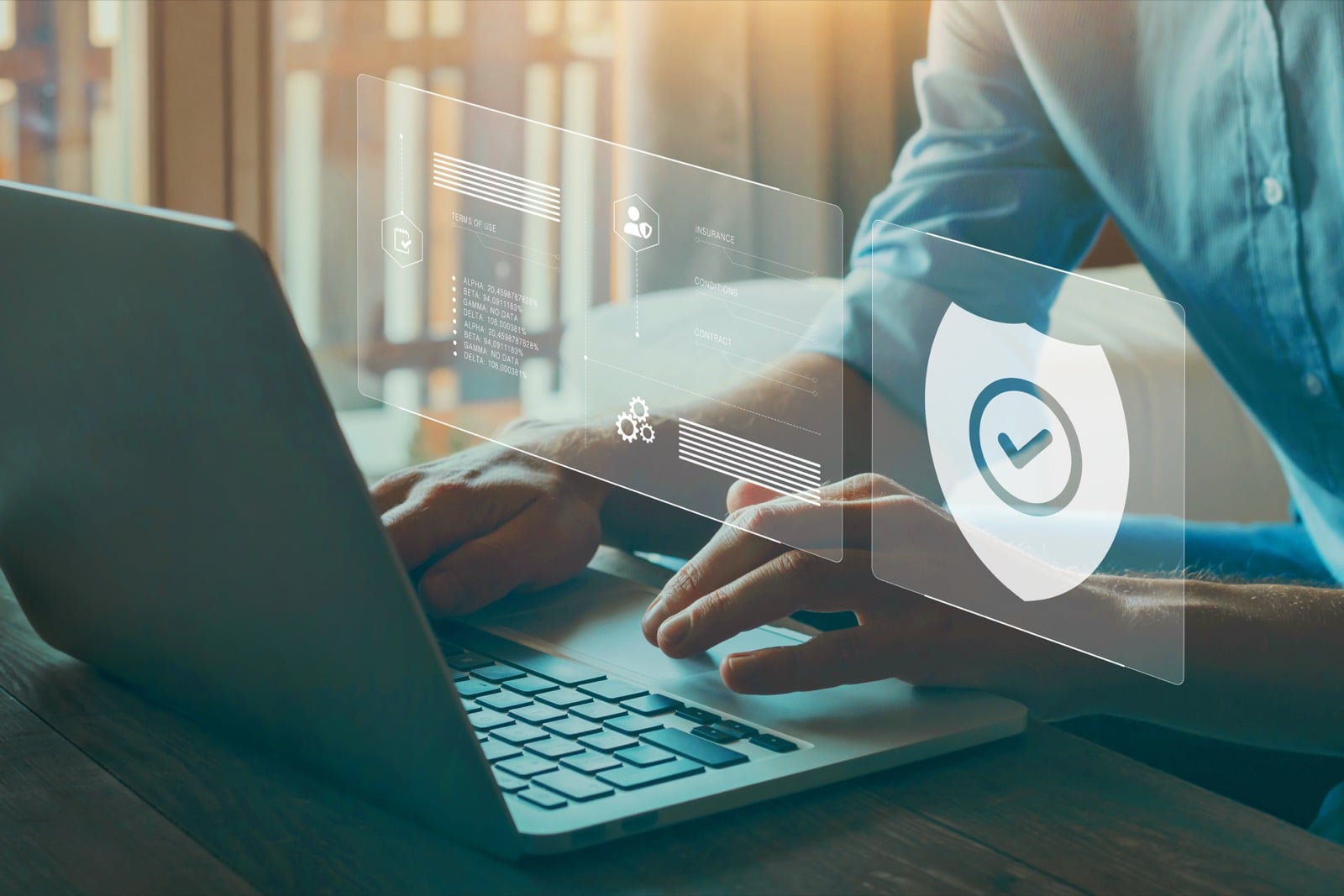 Man at laptop with floating security shield & checkmark hologram