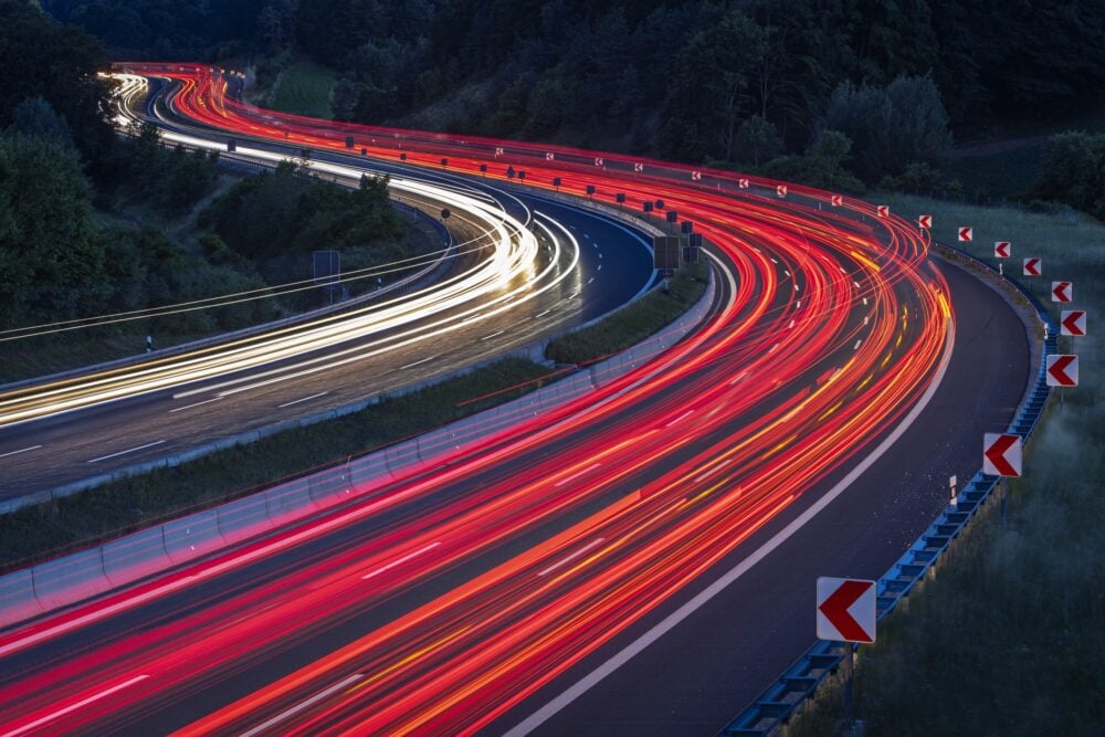 Abstract red and white car and truck car light trails on a multiple lane winding highway